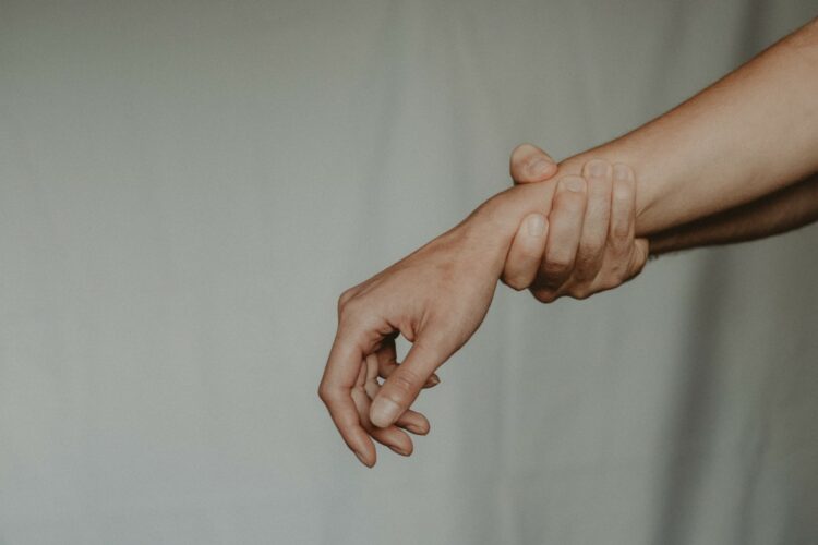 Person holding their wrist
