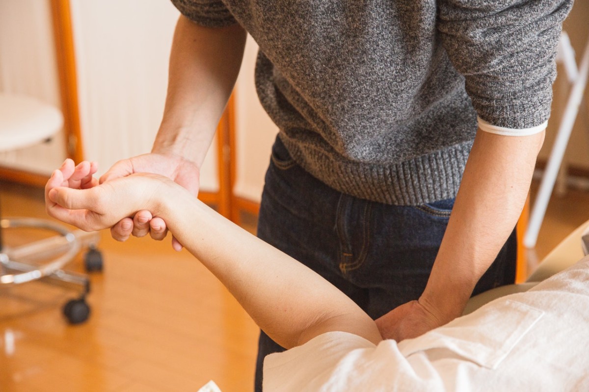 woman massaging hand and wrist of patient