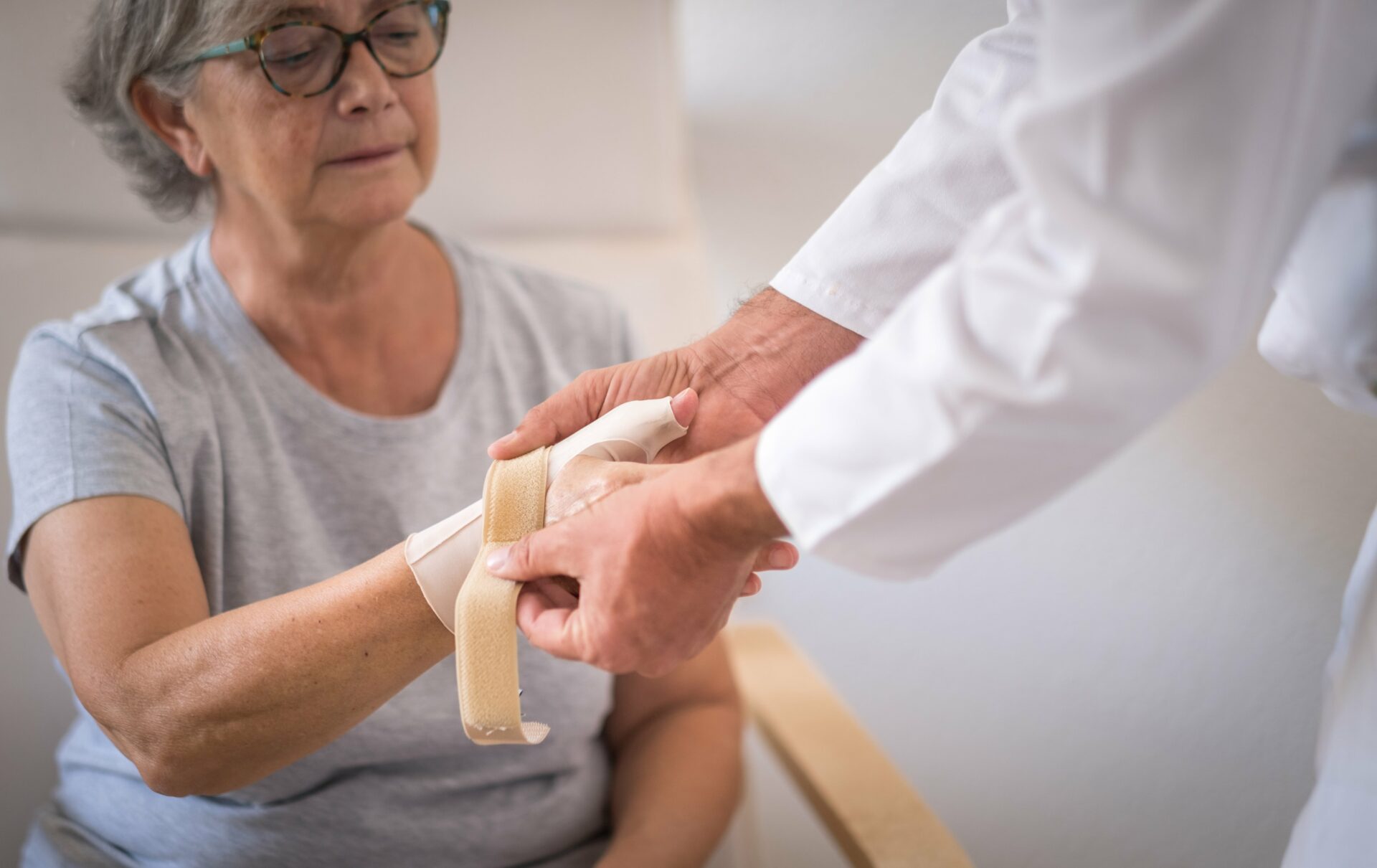 Elderly woman receiving after care treatment from thumb arthritis treatment