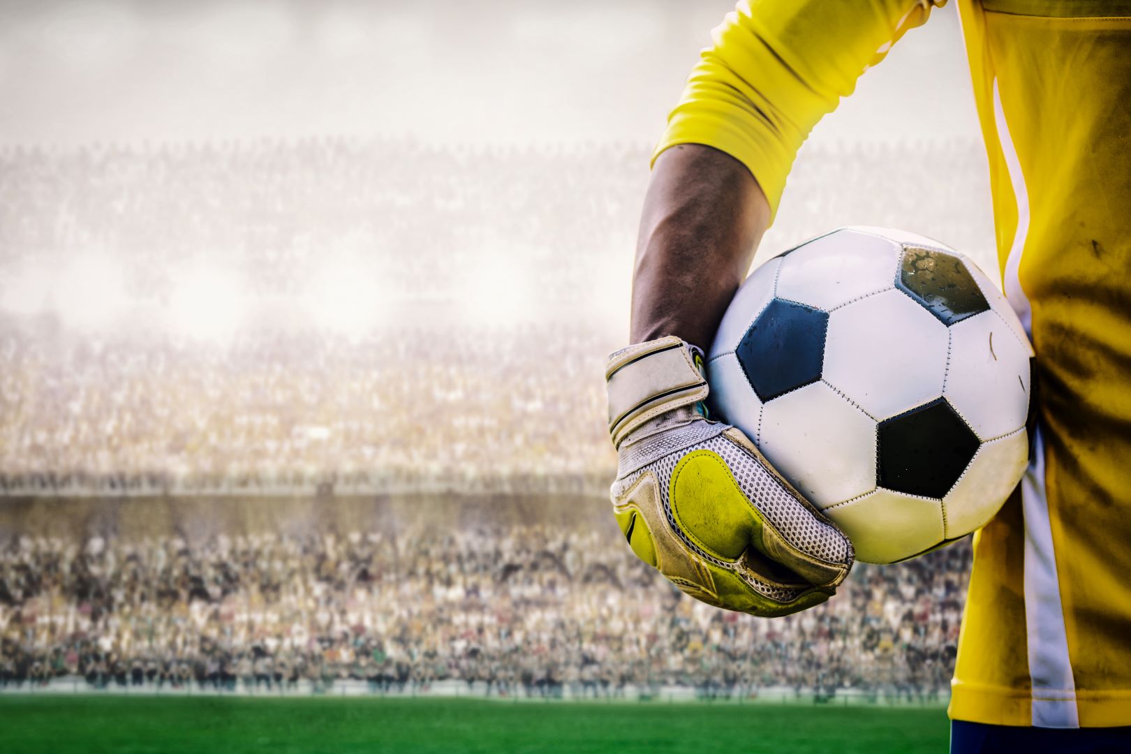 goalkeepers arm, holding a football with gloves on